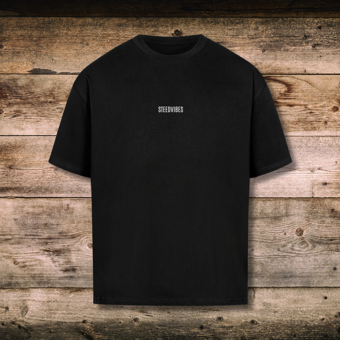 Oversized Herren-Shirt mit Spruch IN HORSE WE TRUST in Schwarz vorne auf Holz