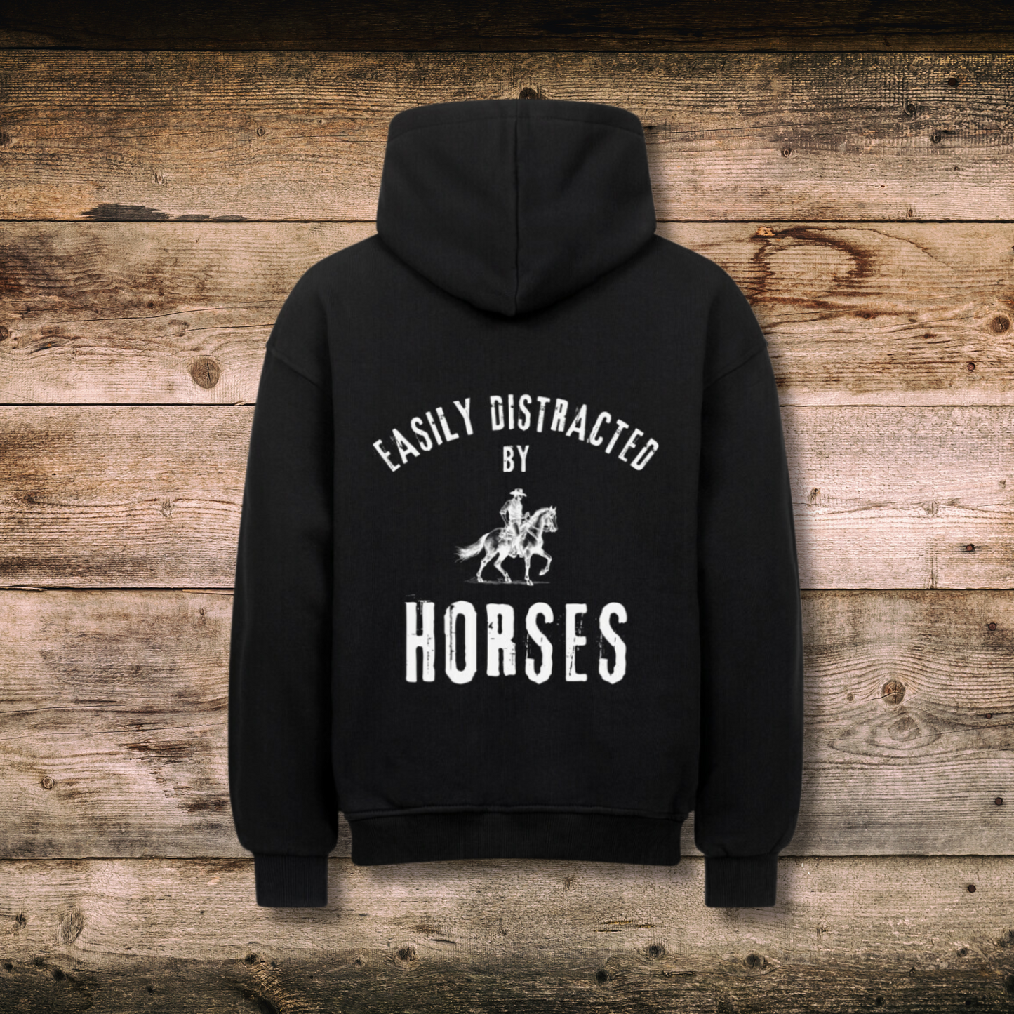 Oversized Damen-Hoodie EASILY DISTRACTED Schwarz hinten auf Holz