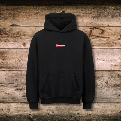 Oversized Damen-Hoodie GOOD RIDES in Schwarz vorne auf Holz